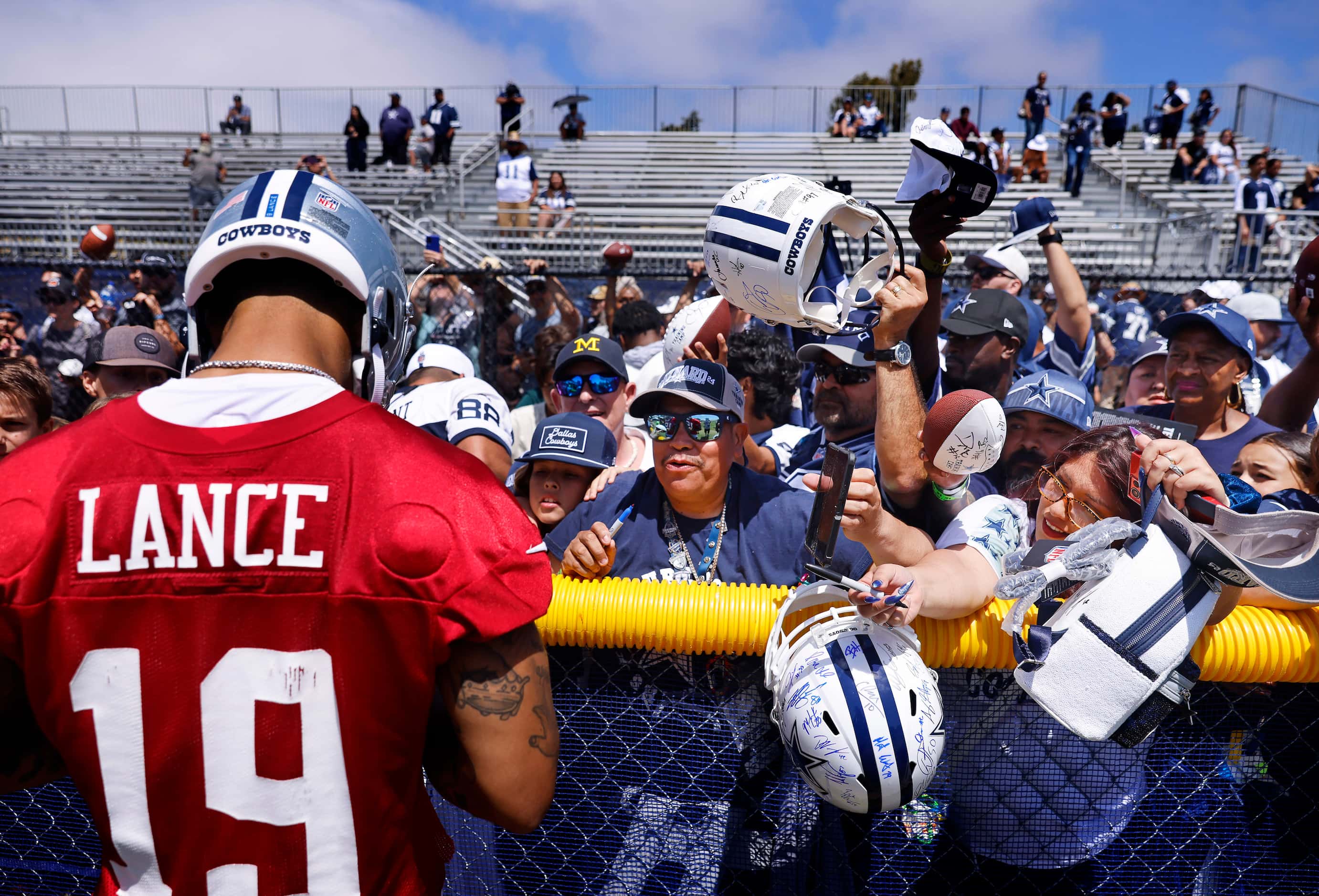 Dallas Cowboys fans reach for an autograph from quarterback Trey Lance following a training...