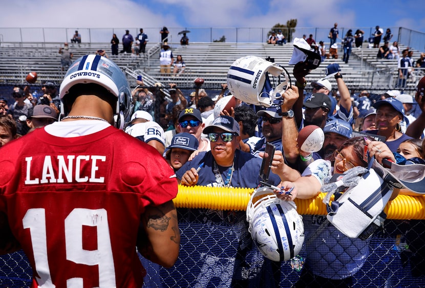 Dallas Cowboys fans reach for an autograph from quarterback Trey Lance following a training...