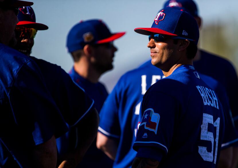 Texas Rangers relief pitcher Matt Bush (51) talks with teammates during a spring training...