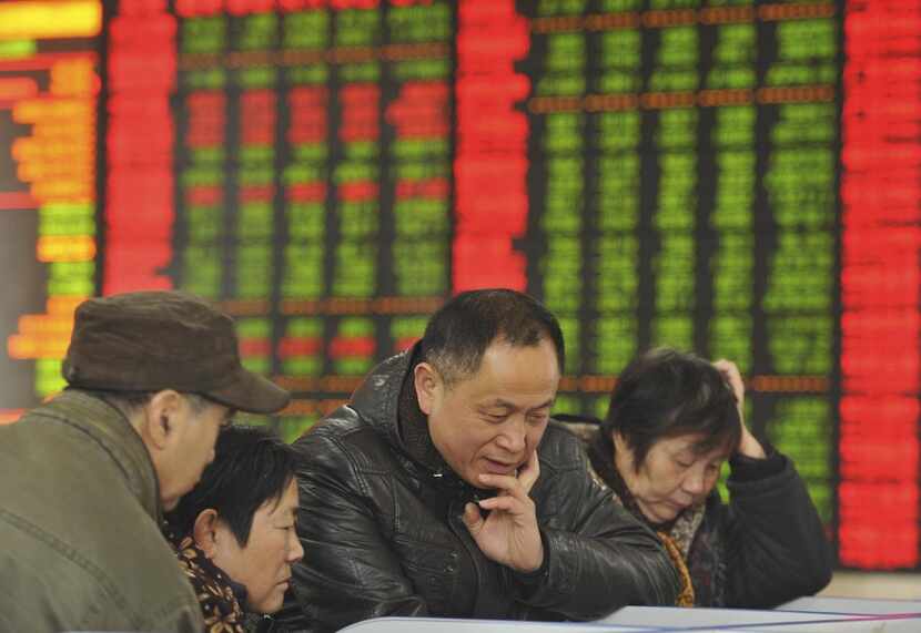 In this Friday, Nov. 27, 2015, file photo, Chinese investors monitor stock prices at a...