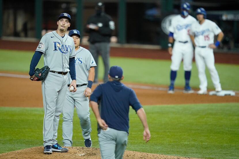 Tampa Bay Rays starting pitcher Blake Snell reacts as manager Kevin Cash comes out of the...