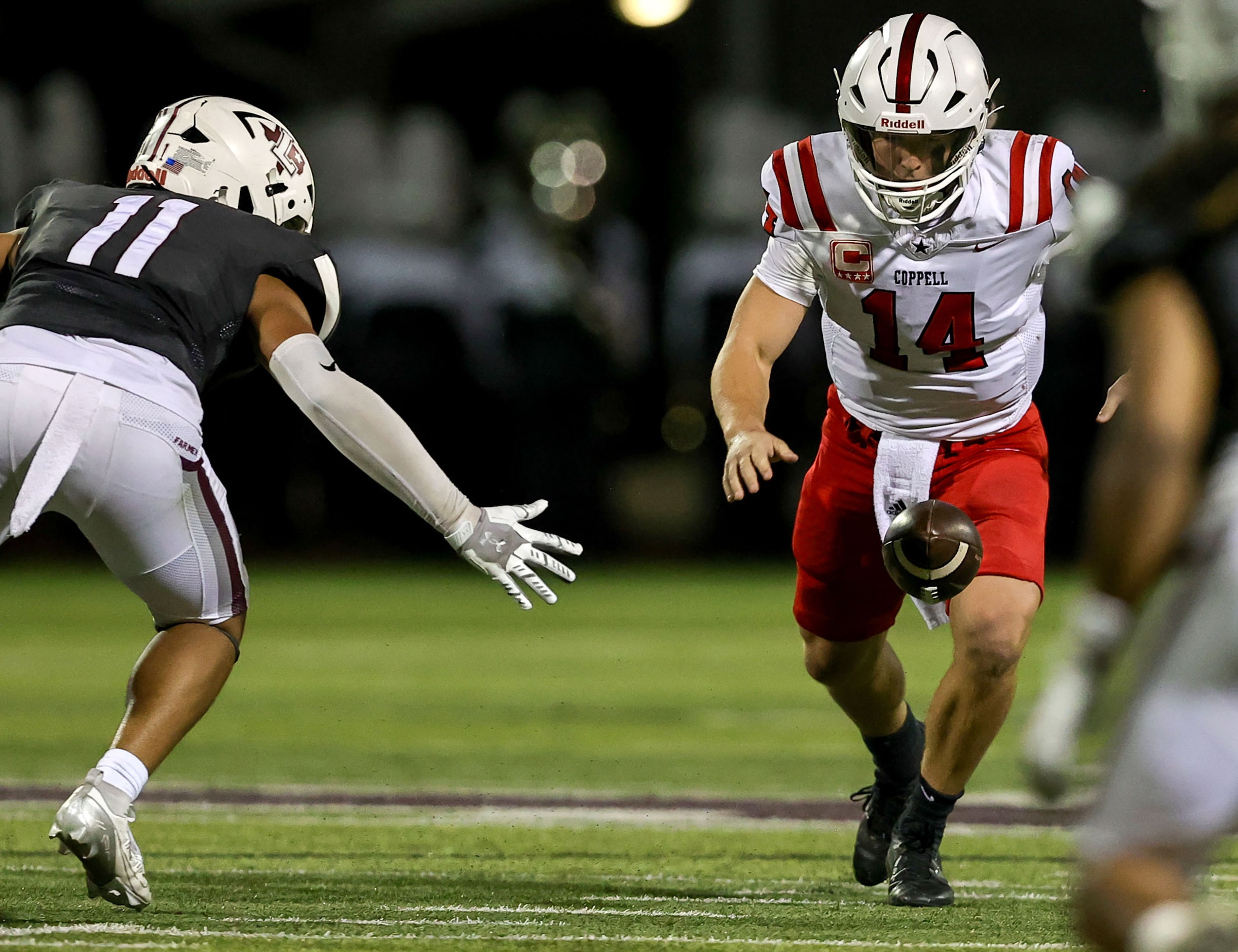 Coppell quarterback Edward Griffin (14) fumbles the ball in front of Lewisville defensive...