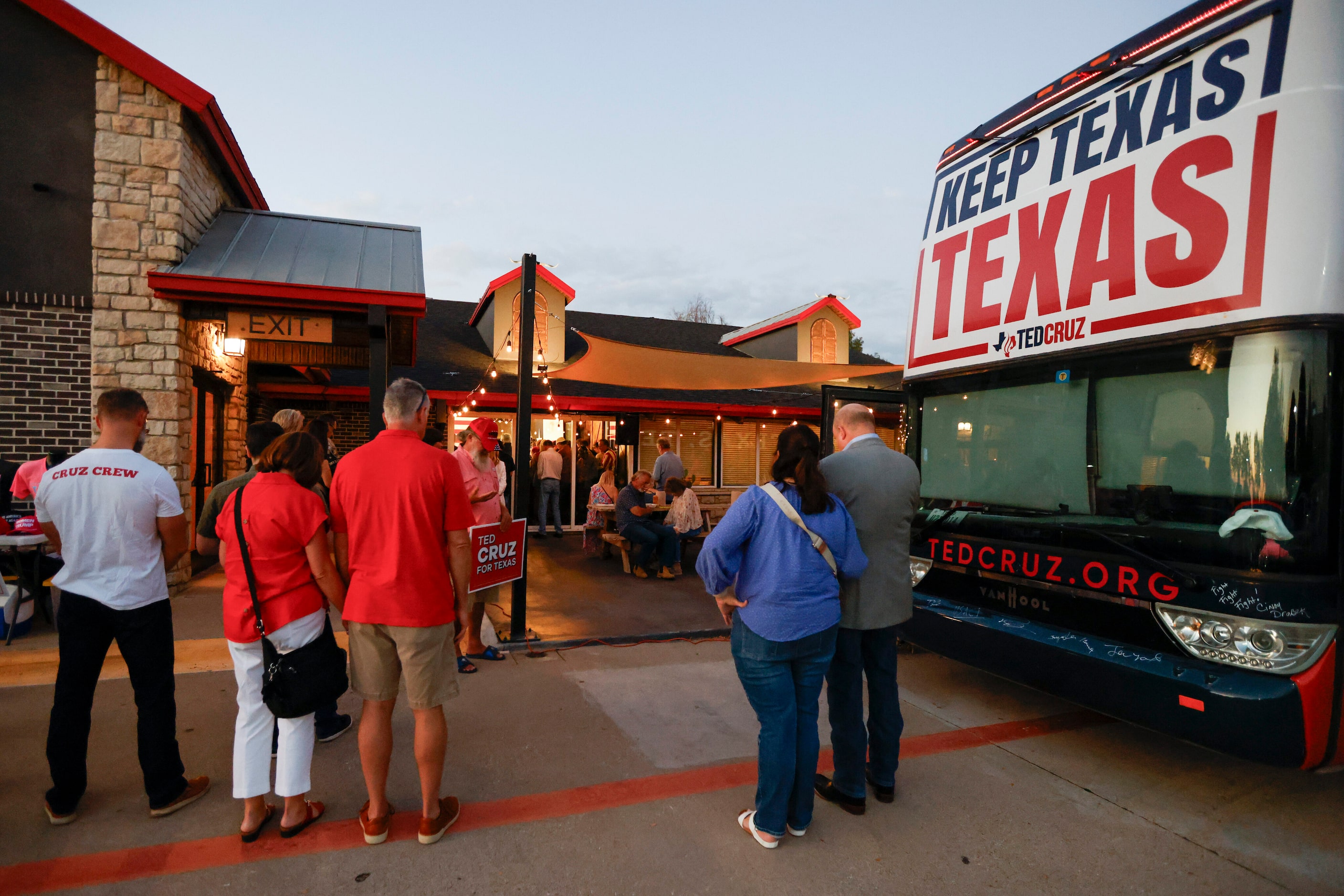 People bow their heads in prayer at the start of a campaign rally for Senator Ted Cruz...