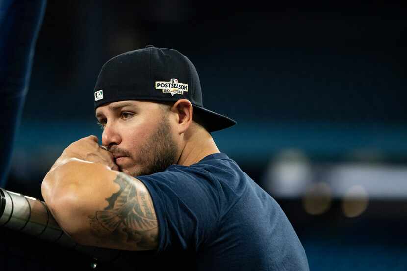 Seattle Mariners infielder Ty France watches from behind the batting cage during a baseball...