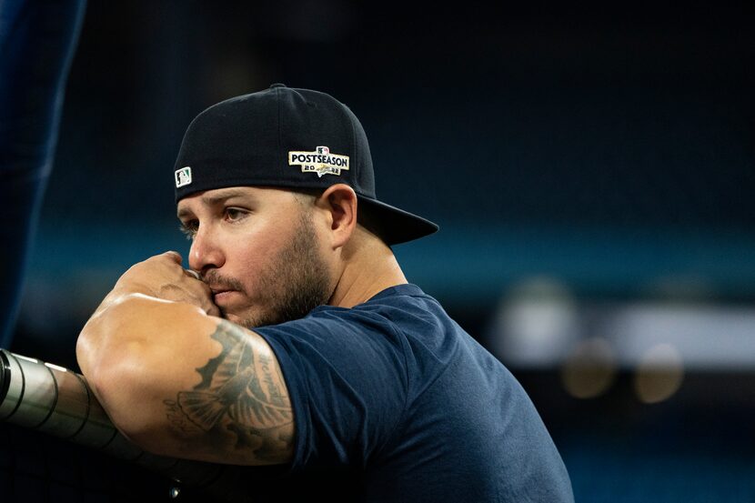 Seattle Mariners infielder Ty France watches from behind the batting cage during a baseball...