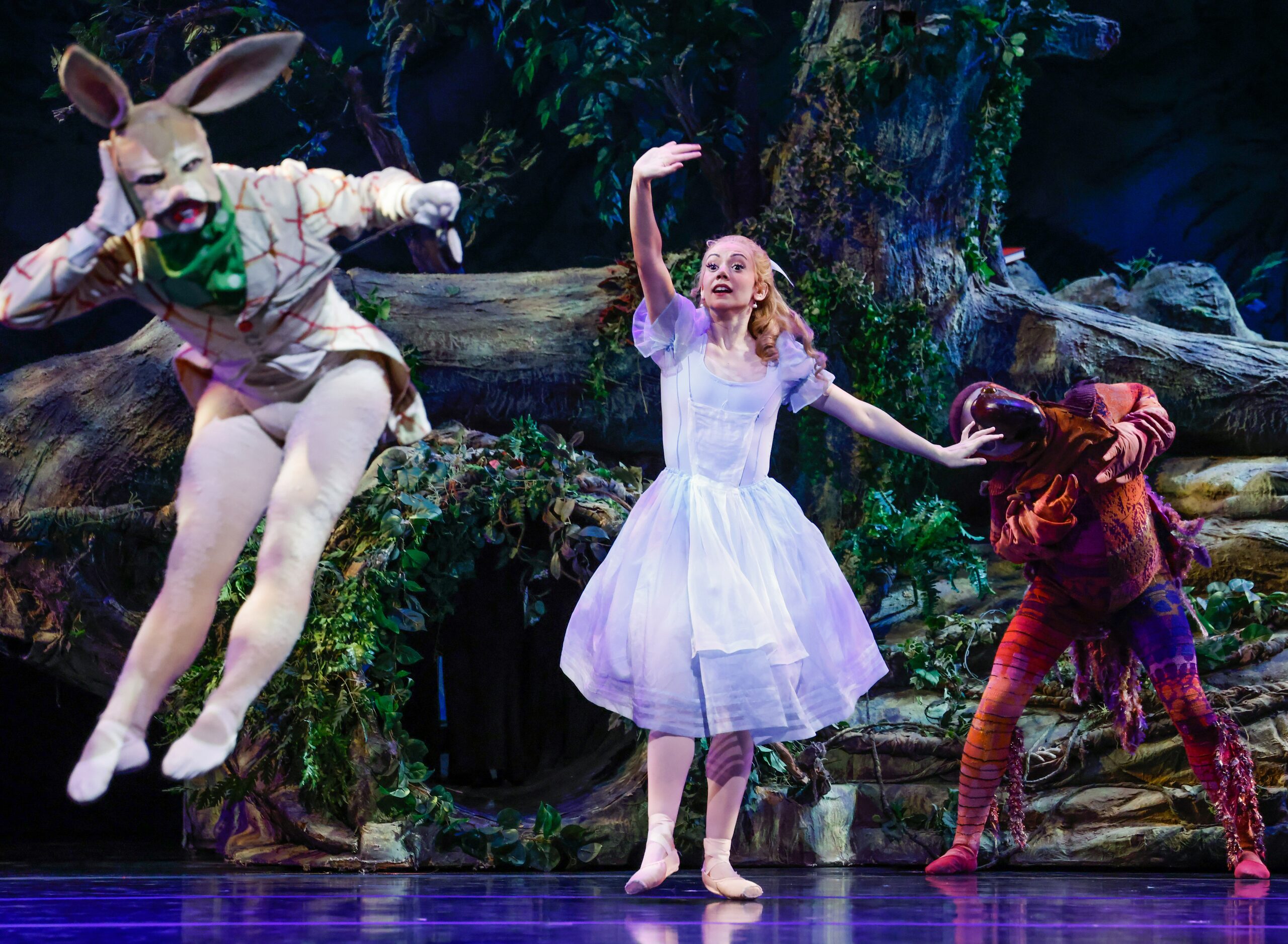 Alice (Alexandra F. Light, center) tries to get the attention of the White Rabbit (Riley...