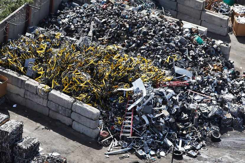 Hundreds of yellow Ofo bikes are piled up at CMC Recycling in Dallas, destined to be scrap...