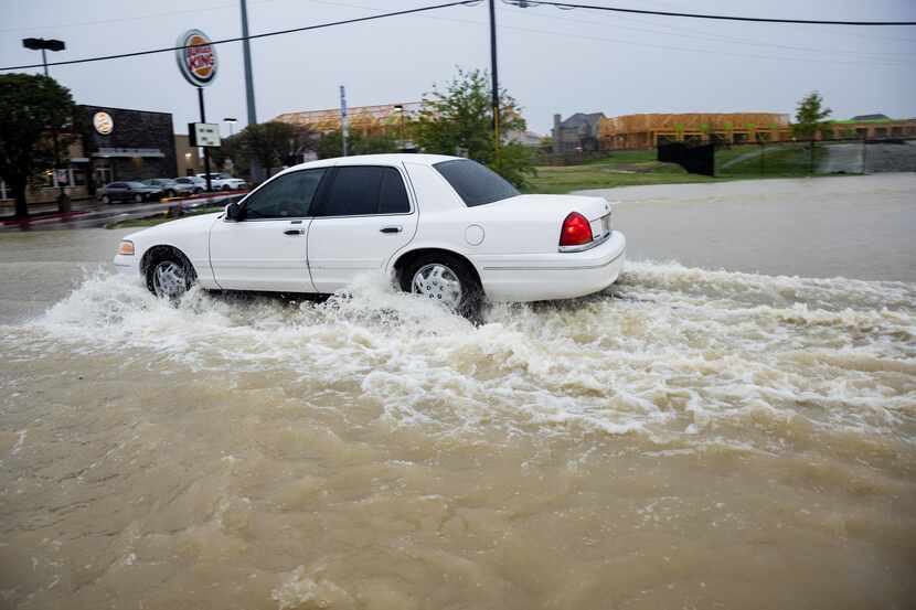 Drivers go through the flooded road at Military Parkway and Highway 352 on Monday, Aug. 22,...