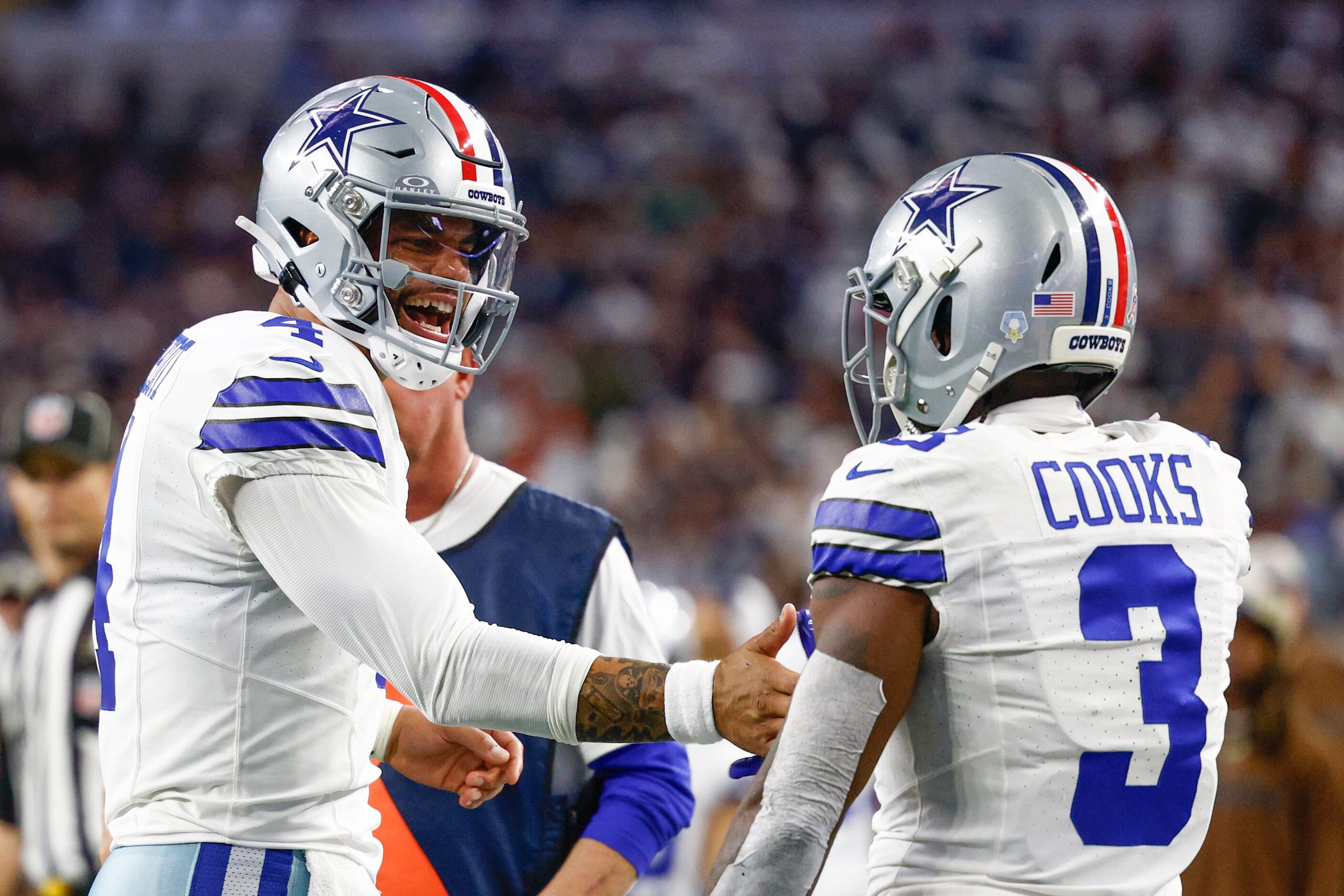 Dallas Cowboys quarterback Dak Prescott (4) congratulates wide receiver Brandin Cooks (3) on...