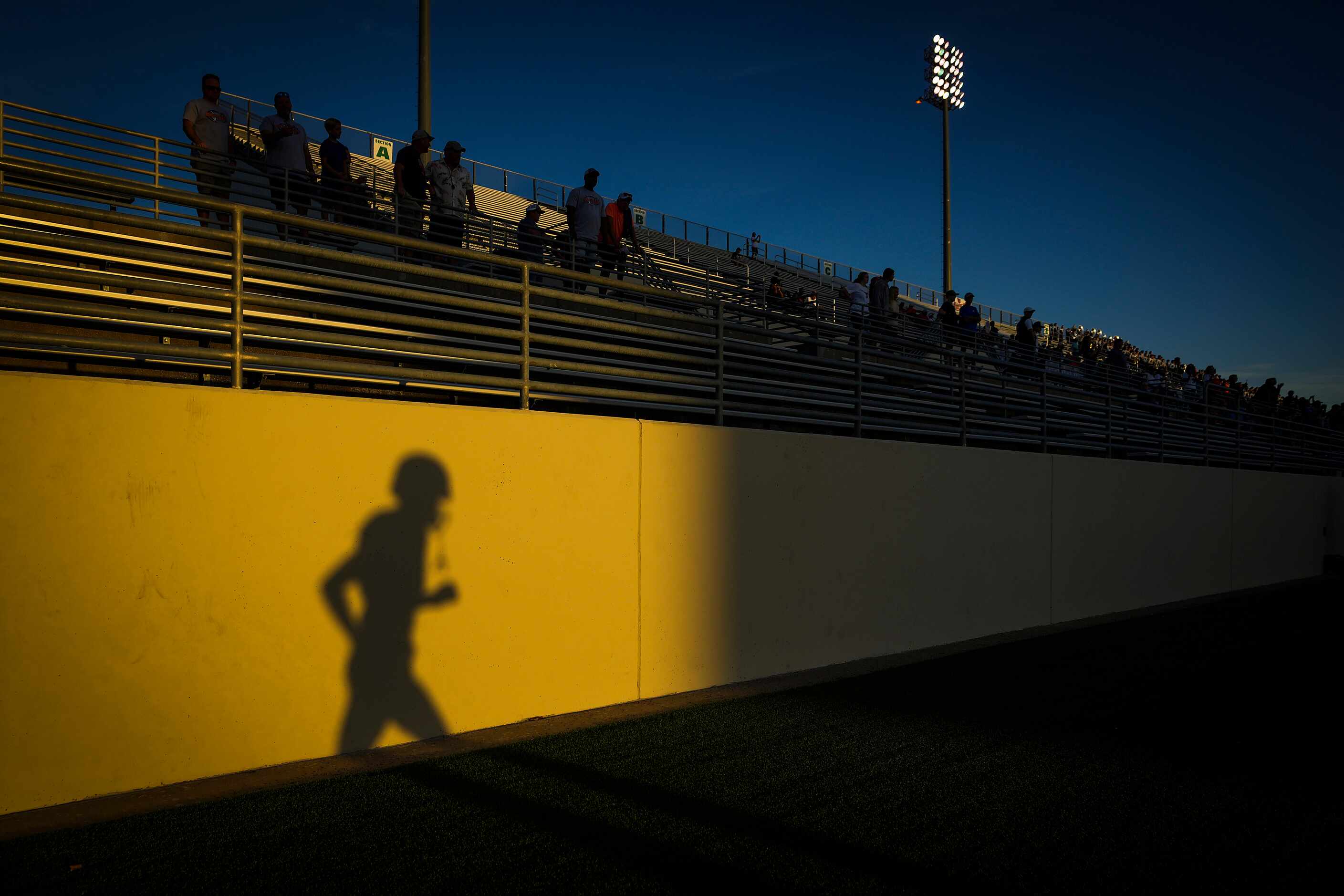 A Frisco Wakeland player casts a shadow while taking the field to face Denton Ryan in a...