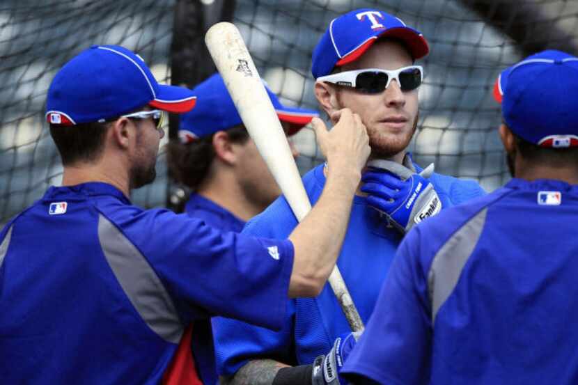 Texas Rangers' Michael Young, left, feels the beard of teammate Josh Hamilton during the...