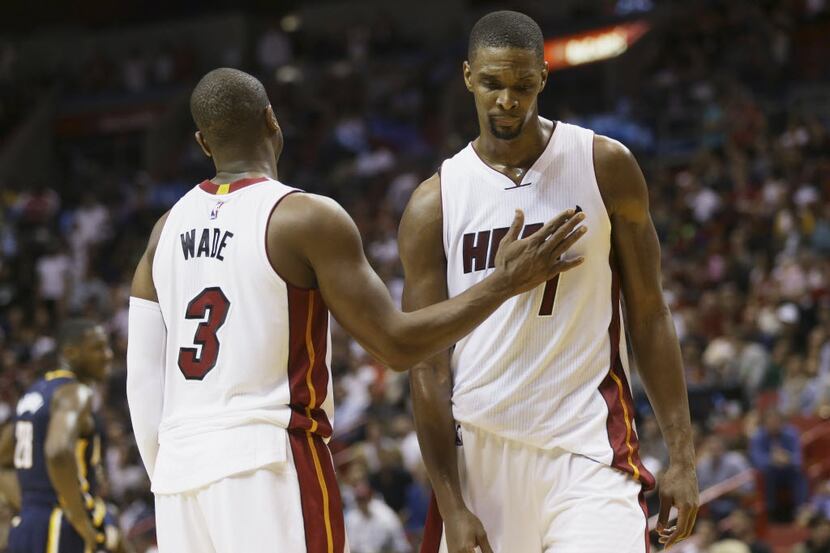 In this Monday, Jan. 4, 2016, photo, Miami Heat's Dwyane Wade (3) pats Chris Bosh (1) on the...