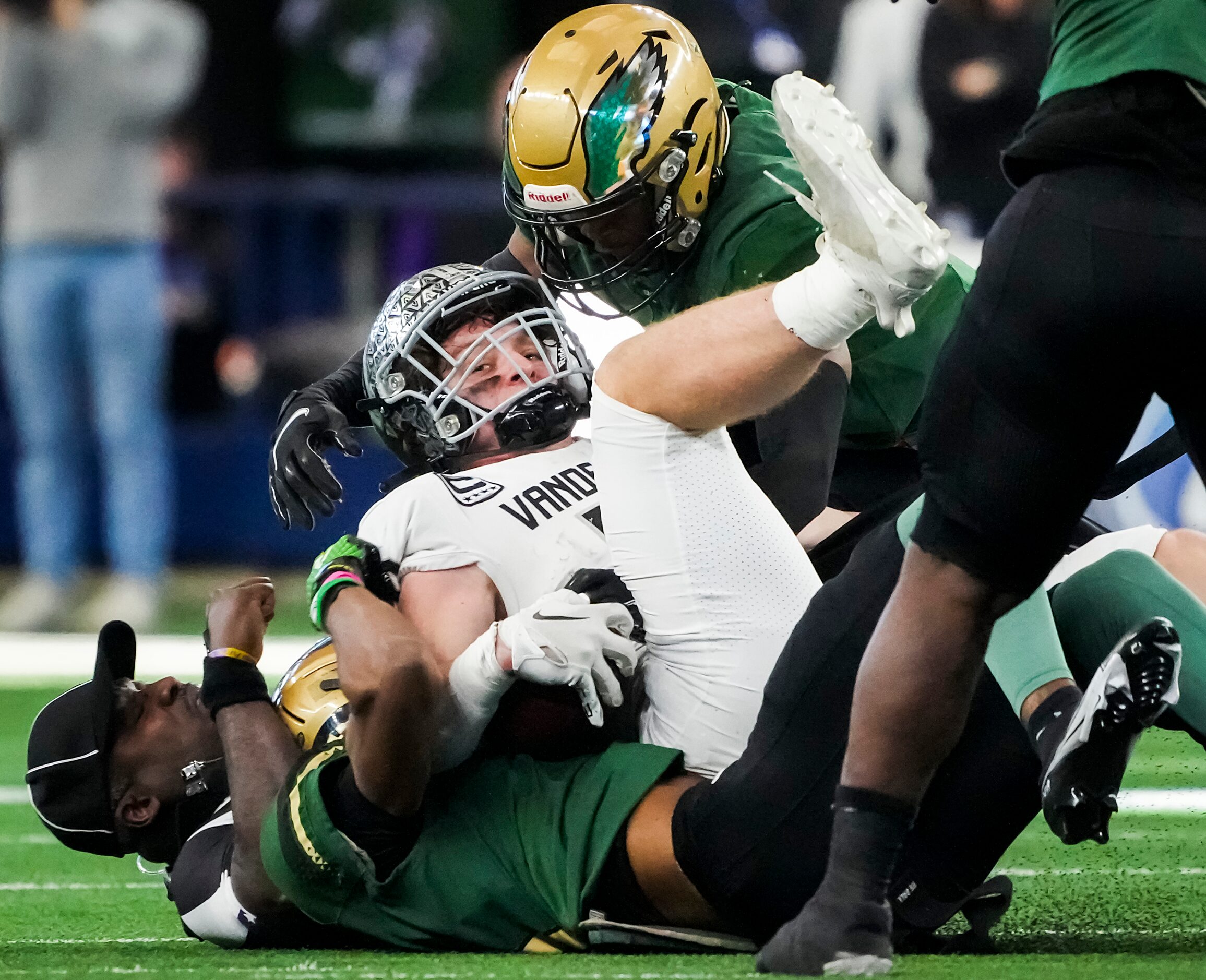 An official winds up at the bottom of the pile as Austin Vandegrift quarterback Brayden...