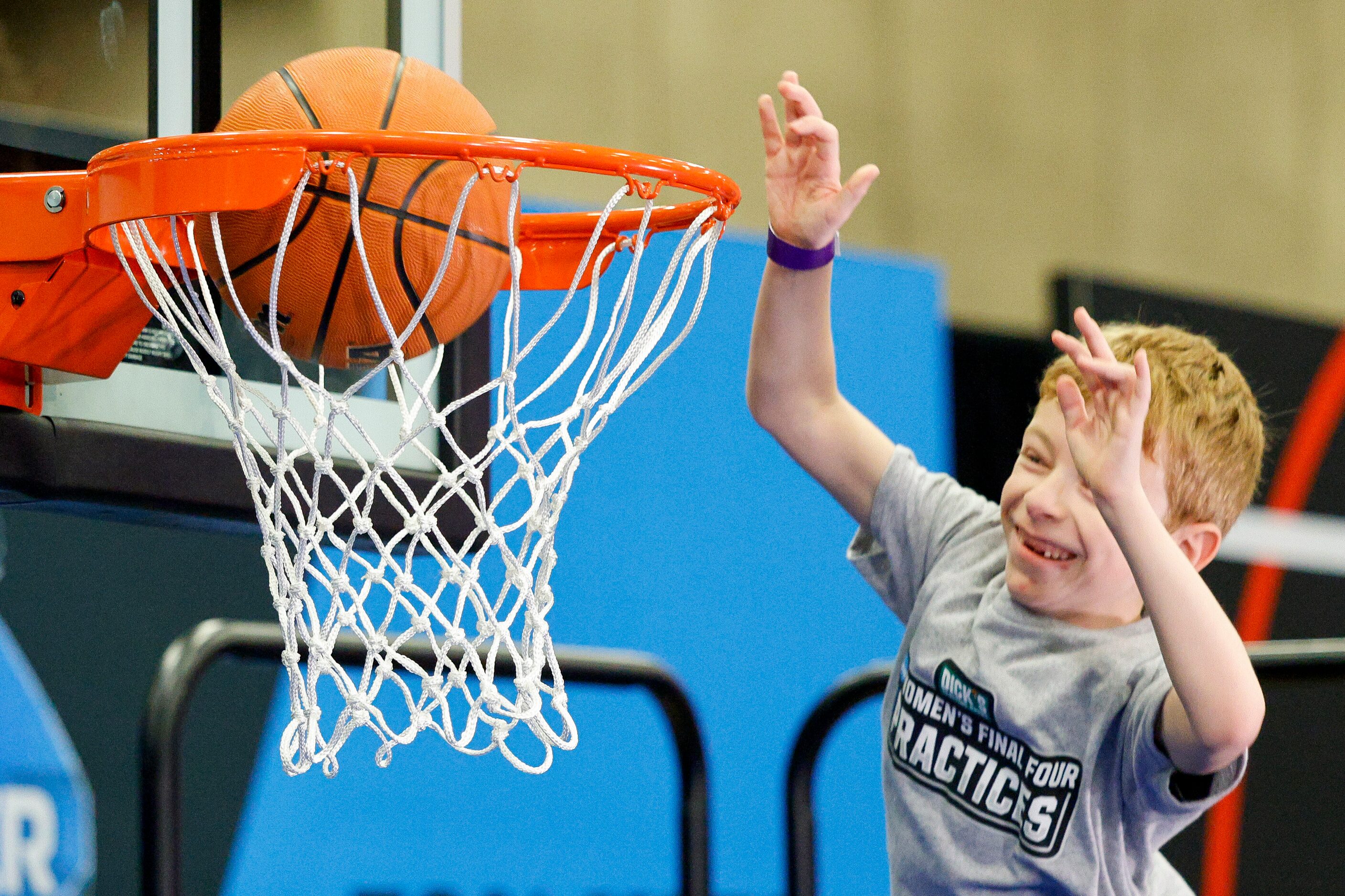 Dawson Park, 8, dunks a ball at a Powerade booth during the NCAA women’s Final Four Tourney...