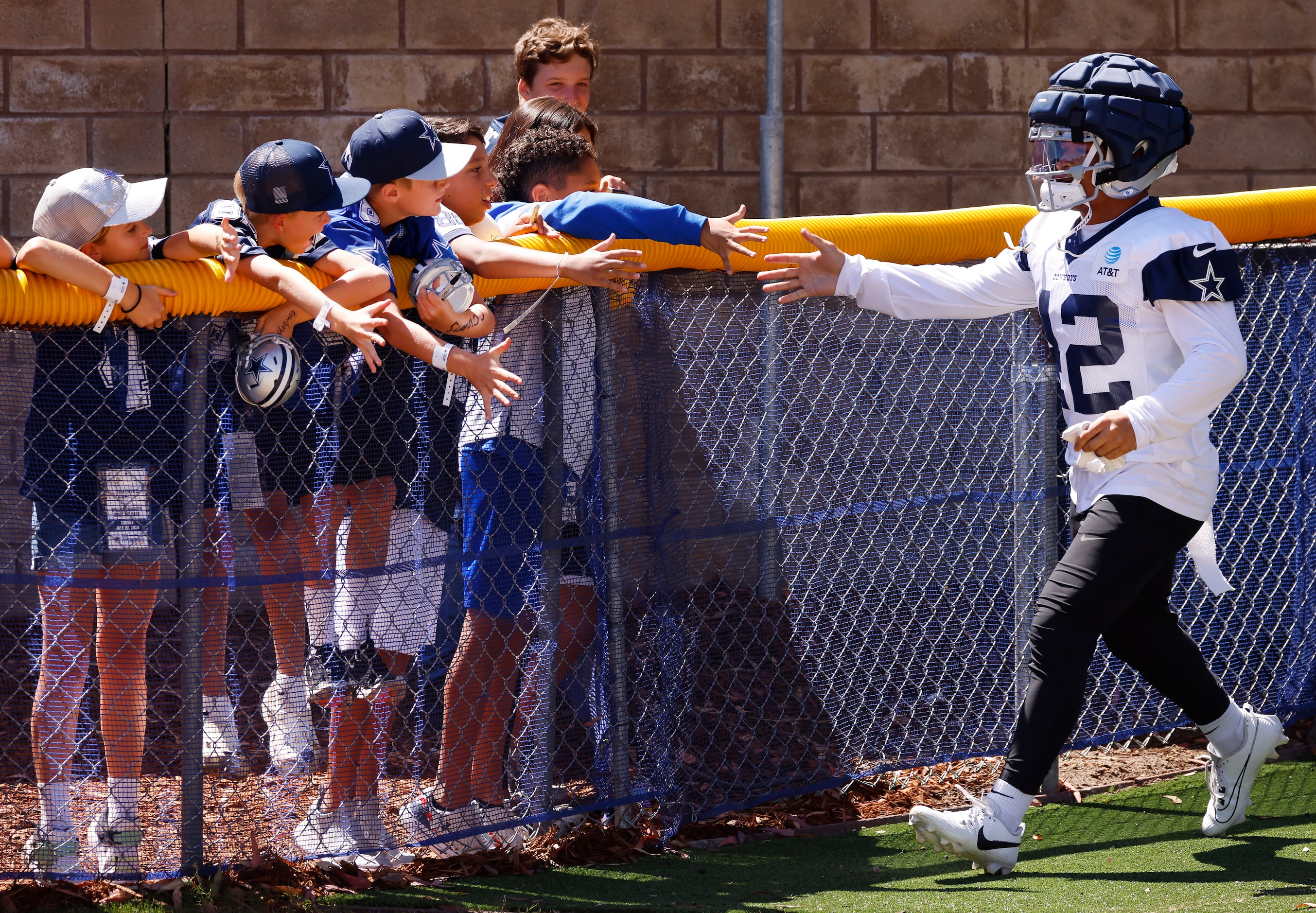 As players arrive for practice, Dallas Cowboys running back Deuce Vaughn (42) slaps hands...