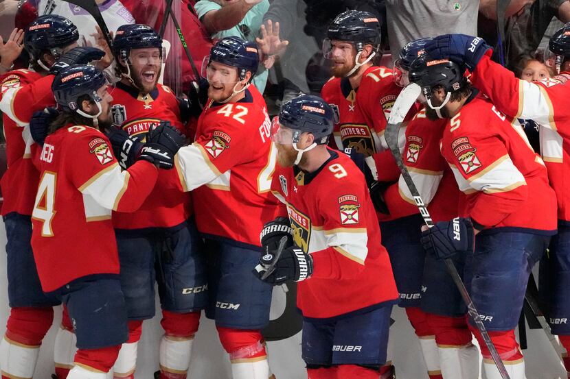 The Florida Panthers team crowd around center Carter Verhaeghe (23), third from left, after...