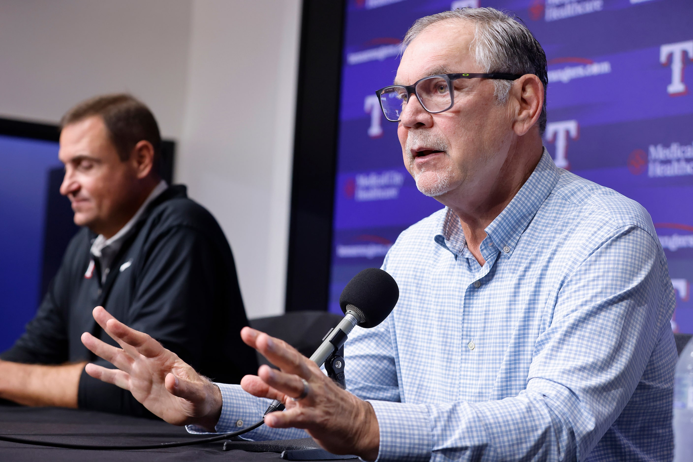 Alongside general manager Chris Young (left), Texas Rangers manager Bruce Bochy responds to...