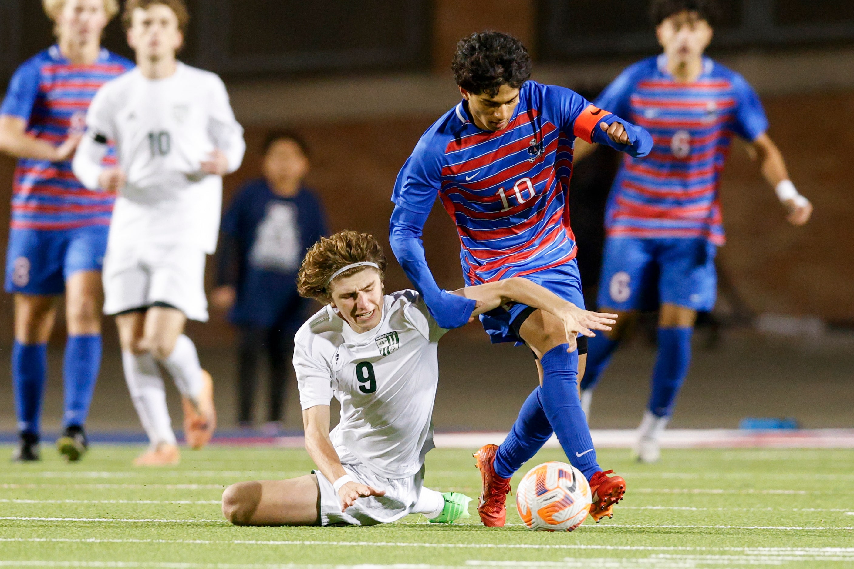 Prosper’s Hayden Crotts (9) falls to the ground as he defends Allen’s Zayan Ahmed (10)...