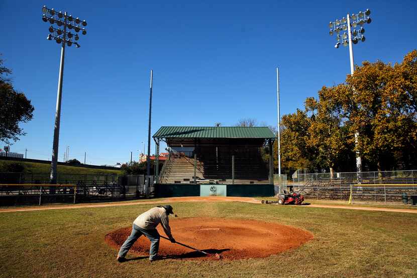 Lawrence Willie, a Dallas Park and Recreation Department employee, fixes holes in the...