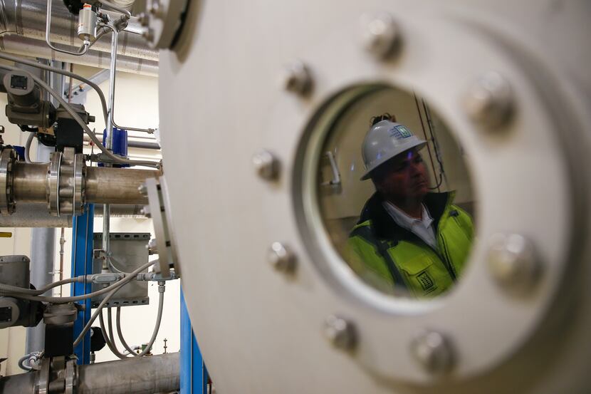 Water production supervisor Roy Cooke is reflected in the viewing window of an ozone...