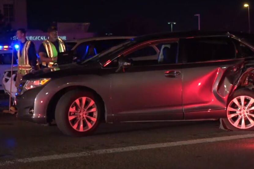 Dallas police look over one of the cars involved in multiple wrecks Friday morning on North...