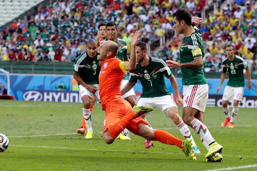 El delantero de la selección de Holanda, Arjen Robben, cae en el área tras sentir un...