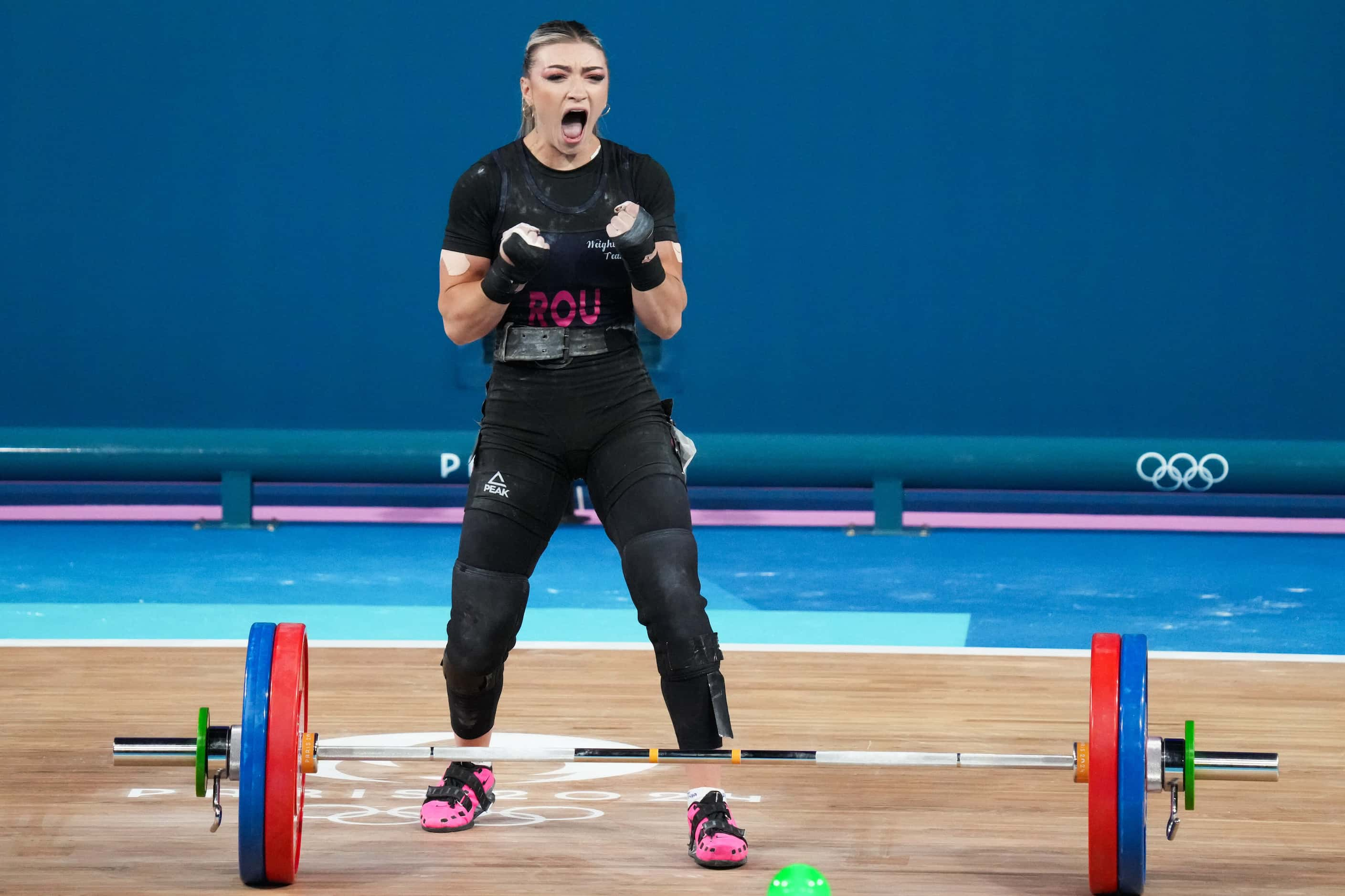 Mihaela Cambei of Romania reacts after lifting 112kg in the in the clean and jerk during...