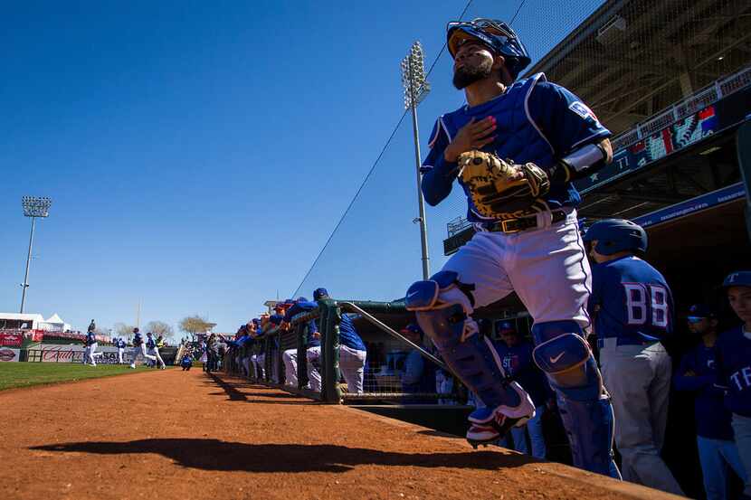 Texas Rangers catcher Robinson Chirinos takes the field before a spring training baseball...