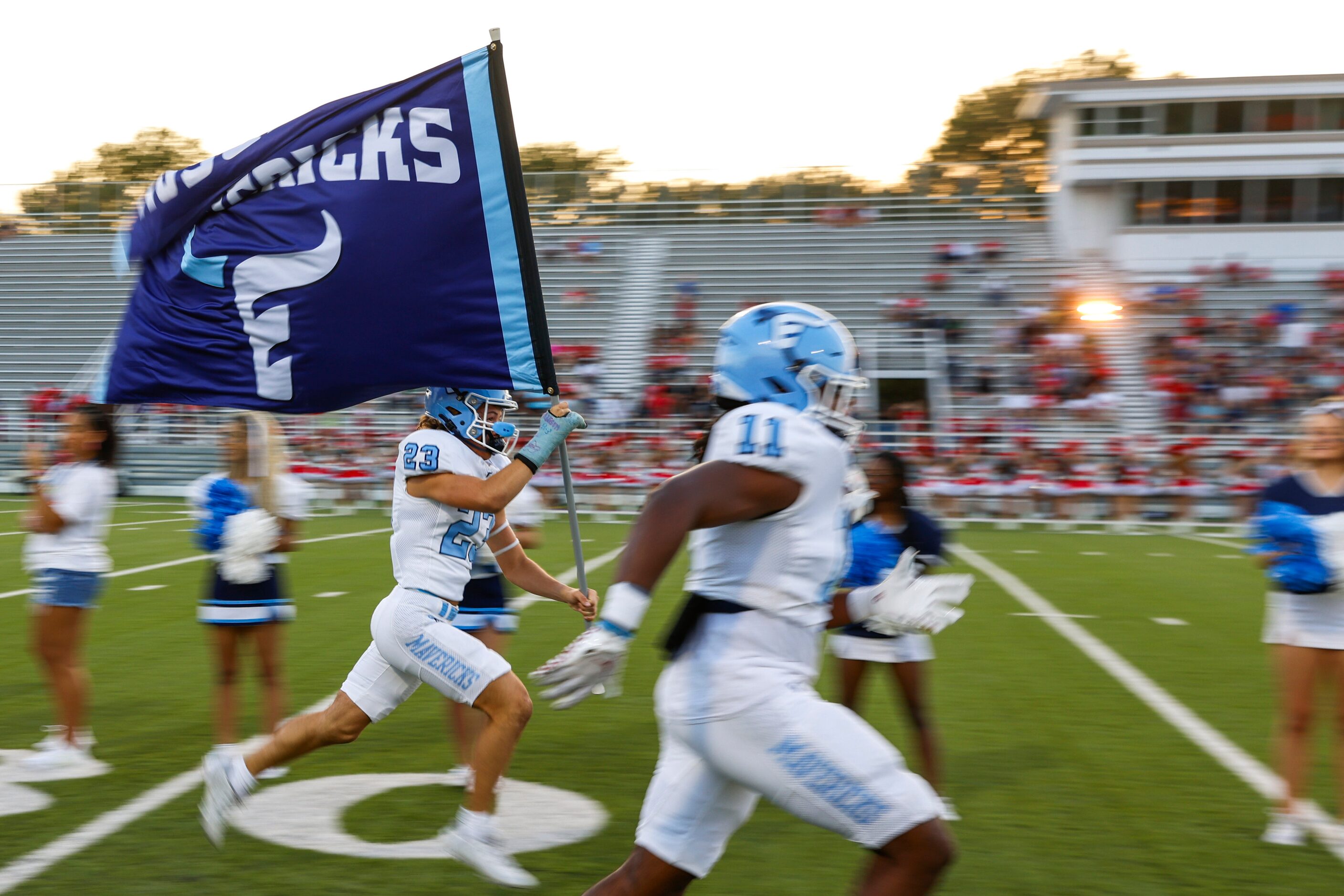 Emerson high players make their entrance to the field ahead of a football game against...