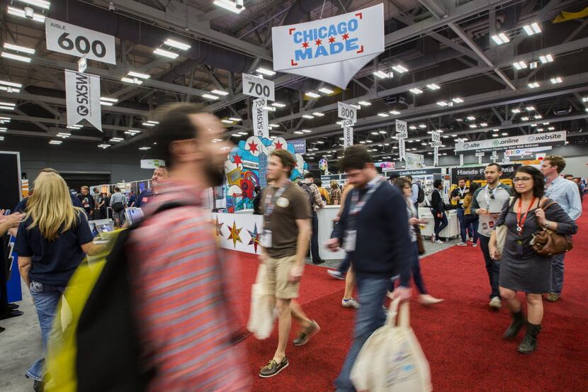 People make their way through a trade show at the Austin Convention Center during the 2015...
