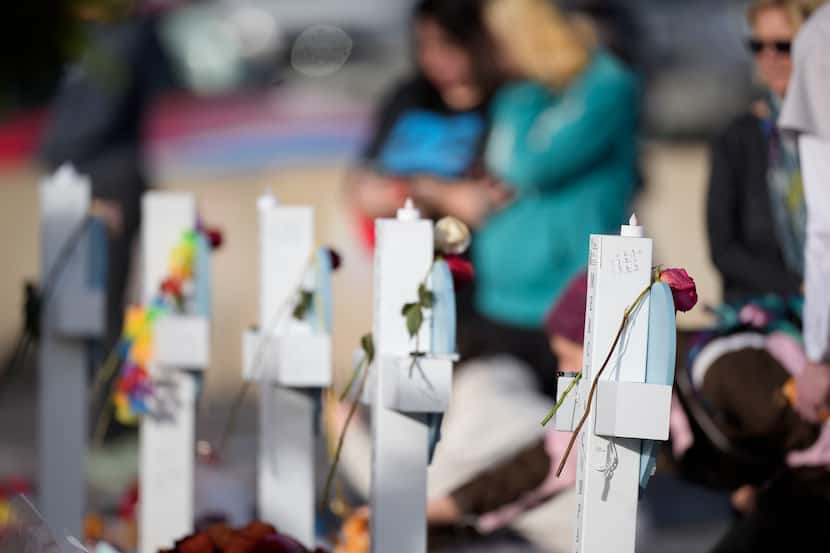 Crosses stand at a makeshift memorial for the victims of a mass shooting over the weekend at...