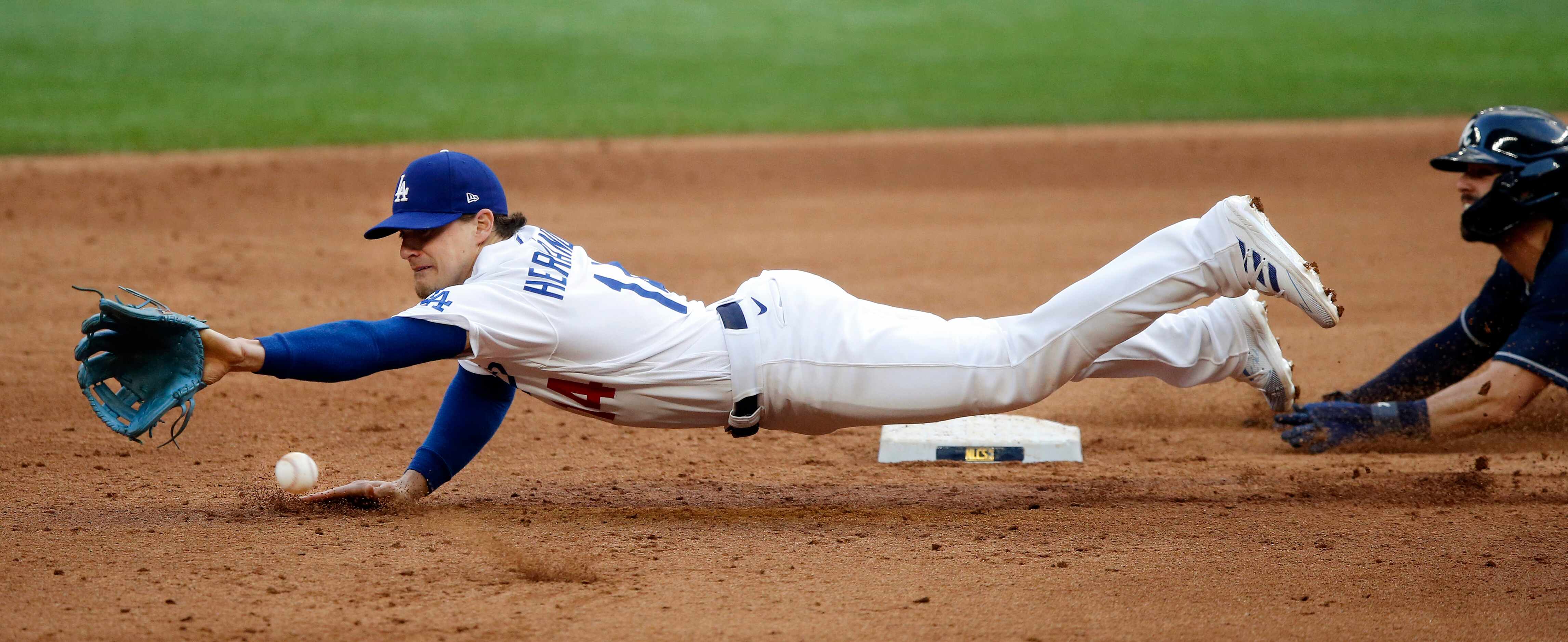 Los Angeles Dodgers second baseman Enrique Hernandez (14) dives for a ball thrown on a...
