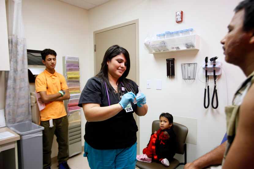 Registered nurse Vanessa Grifaldo prepares to give patient Kashi Ghaley a flu shot at...