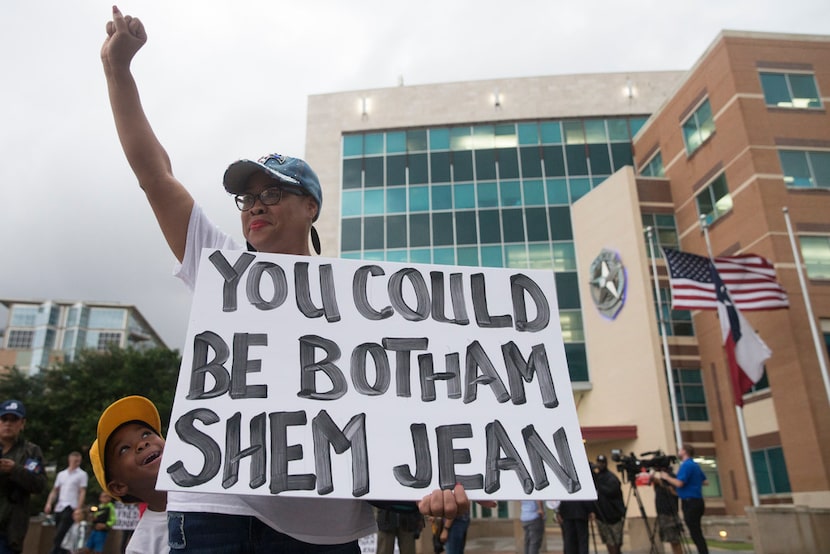 Dr. Pamela Grayson raises her fist as "Young King" Solomon Grayson, 6, peaks out behind her...