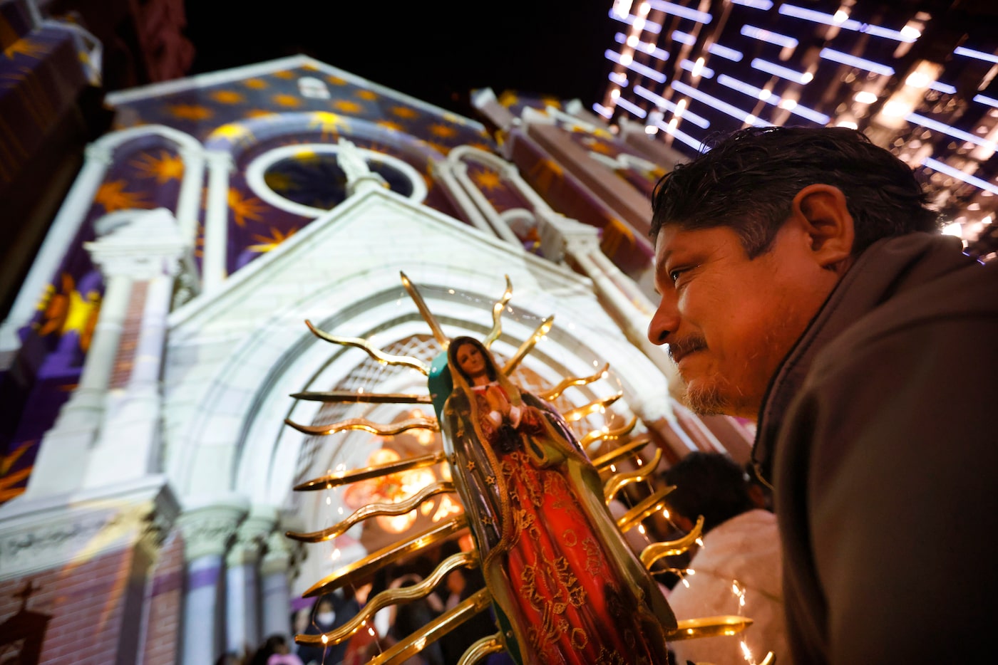 Oscar Garcia of Pleasant Grove waited in line with his father’s lighted statue of Our Lady...