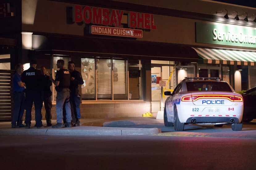 Police stand outside the Bombay Bhel restaurant in Mississauga, Canada, Friday. Canadian...