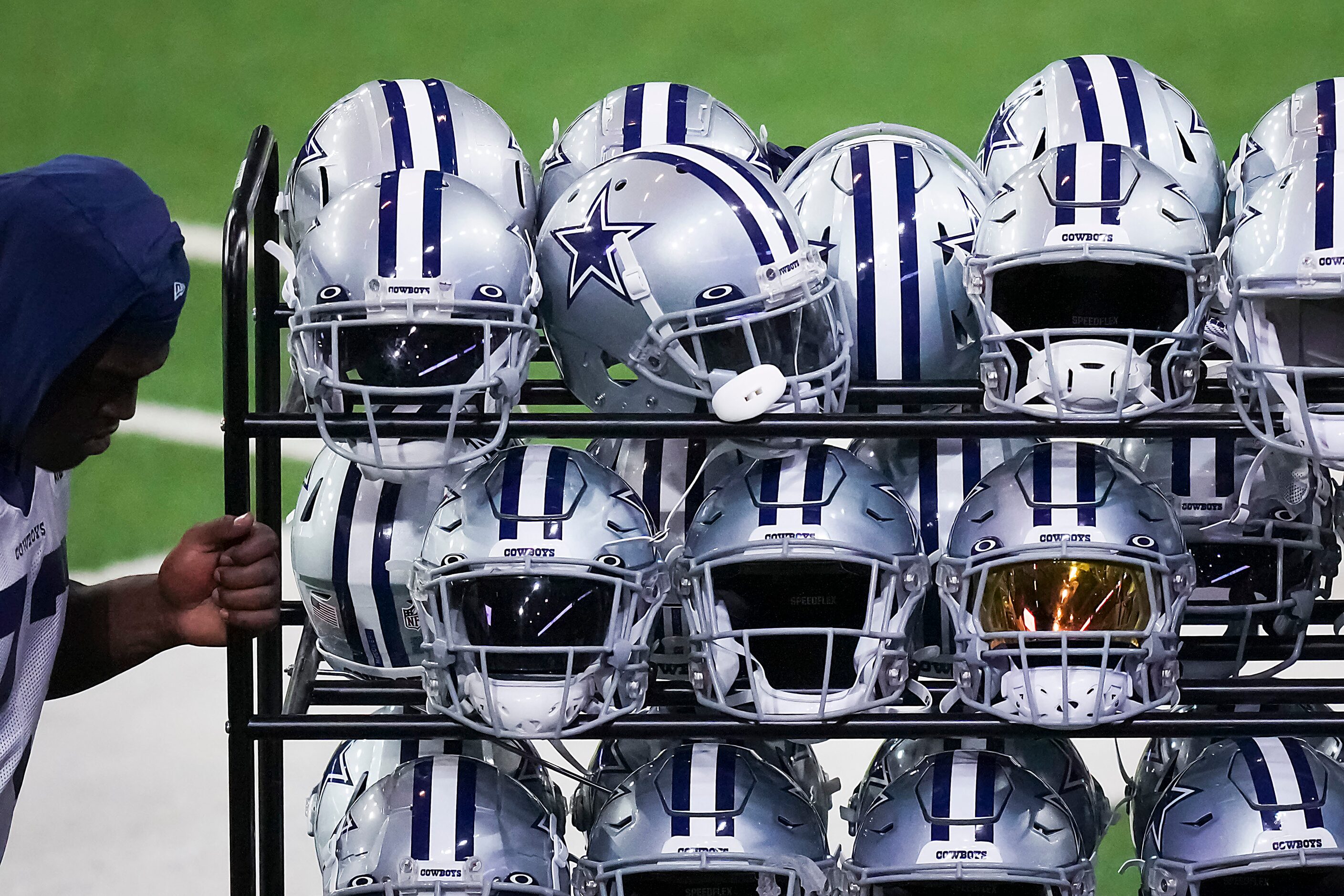 Dallas Cowboys offensive tackle Tyler Smith reaches for a rack of helmets after a training...