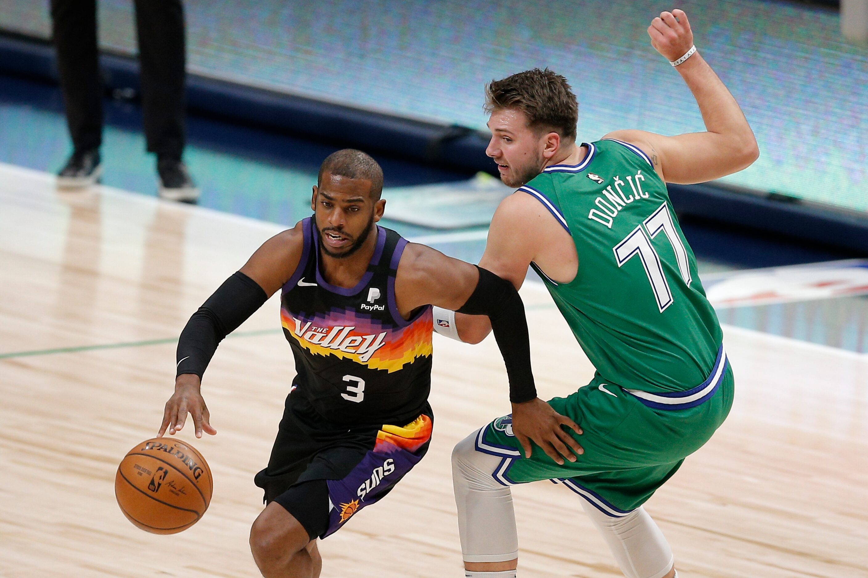 Phoenix Suns guard Chris Paul (3) gets past Dallas Mavericks guard Luka Doncic (77) during...