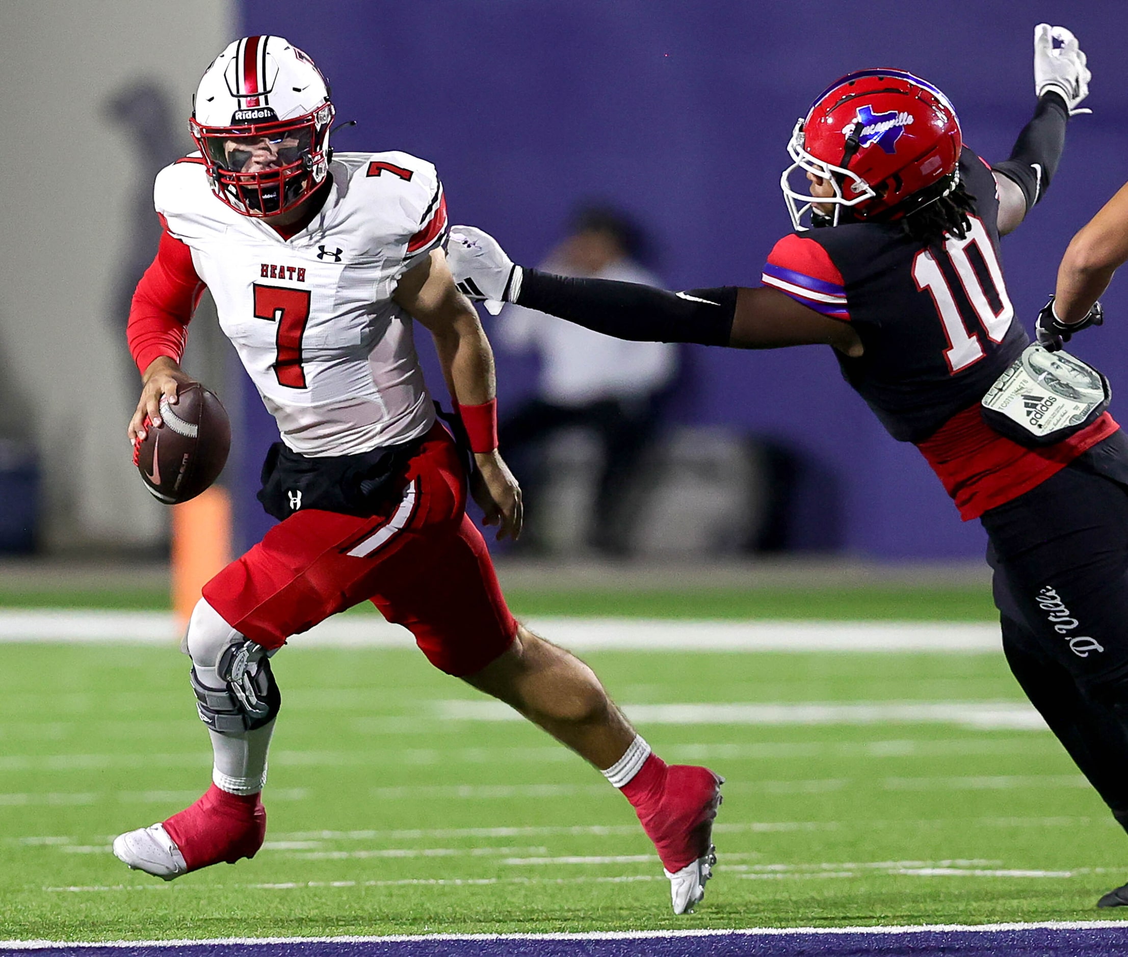 Rockwall Heath quarterback Caleb Hoover (7) rolls out against Duncanville defensive end...