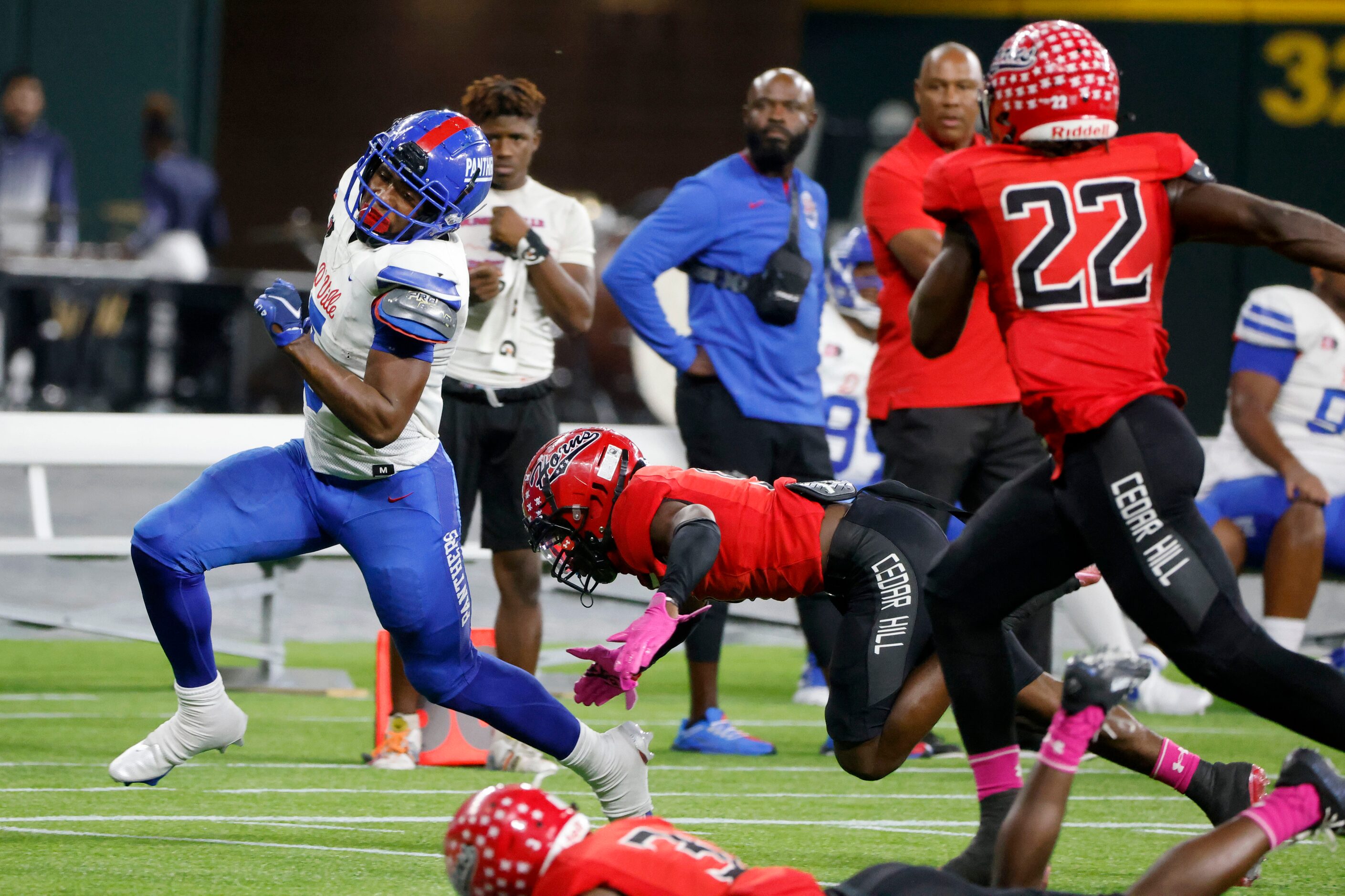 Duncanville running back Malachi Medlock (5), left, runs past Cedar Hill defenders for a...