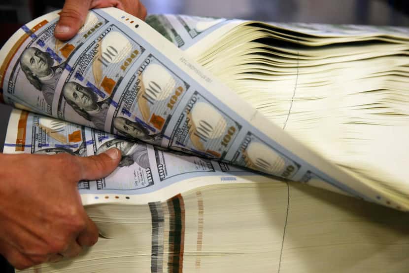 Juan Reyna works on aerating a stack of $100 notes before a digital inspection at the Bureau...