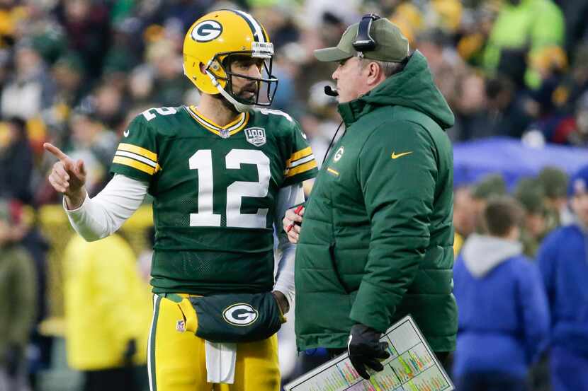 Green Bay Packers head coach Mike McCarthy talks to Aaron Rodgers during the first half of...