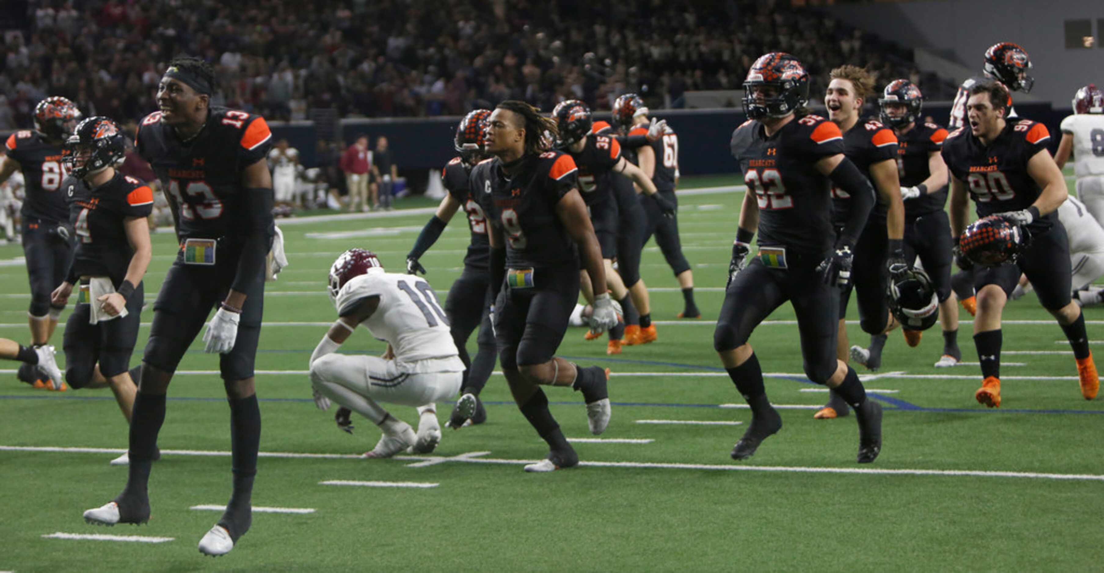 Aledo Bearcats players storm the field as Ennis Lions players including Azain Brown (10)...