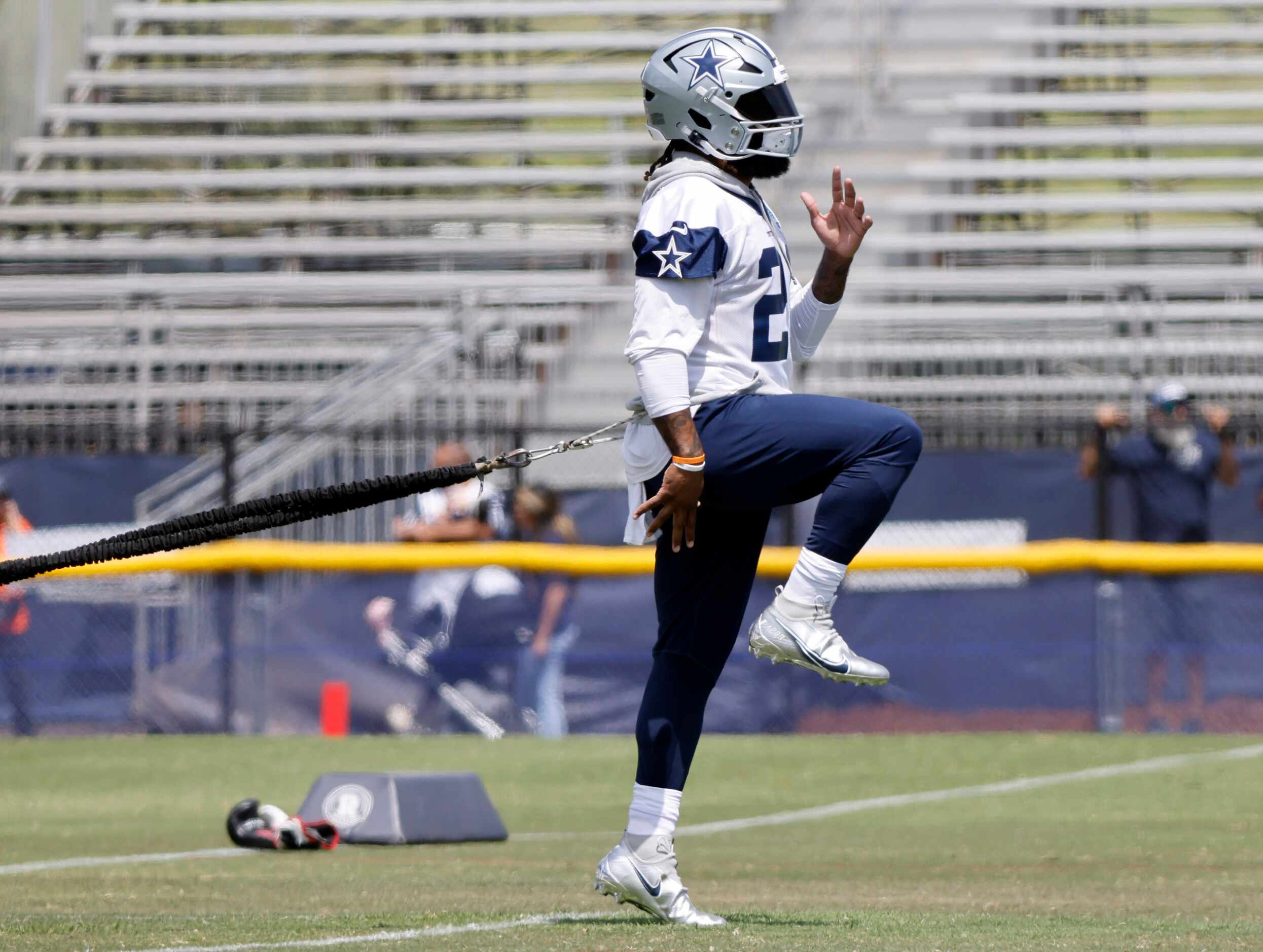 Dallas Cowboys running back Ezekiel Elliott (21) uses an exercise cord to stretch during the...