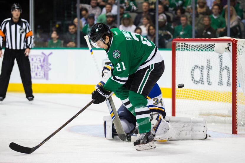 A puck gets past Dallas Stars left wing Antoine Roussel (21) and St. Louis Blues goalie Jake...