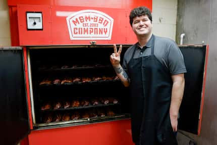 Ribbee’s co-owner Jonny White stands in front of dozens of racks of ribs cooking in an M&M...