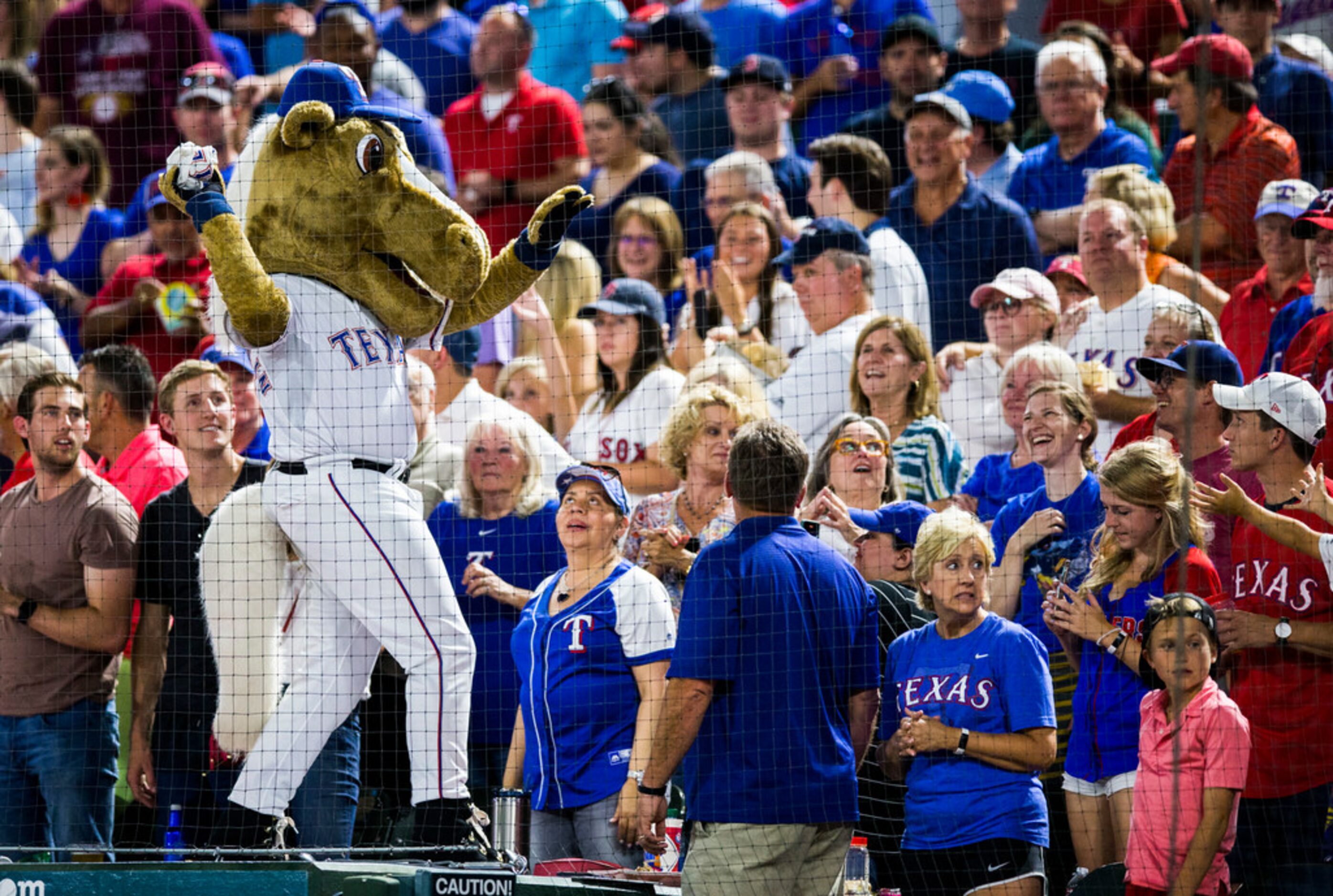 Texas Rangers mascot Rangers Captain throws out a t-shirt during the seventh inning stretch...