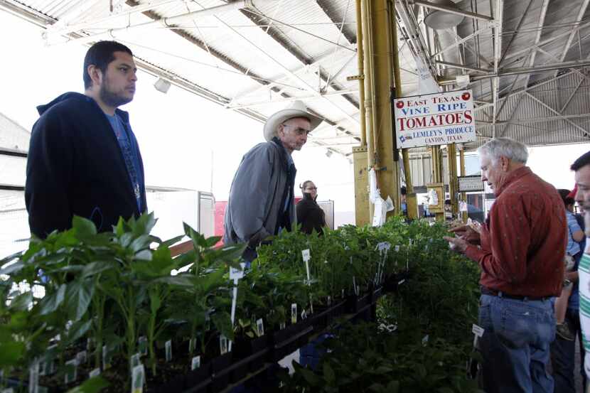 J.T. Lemley of Lemley's Farm, center top, assists customer Jerry Donoho, right, of Lancaster...