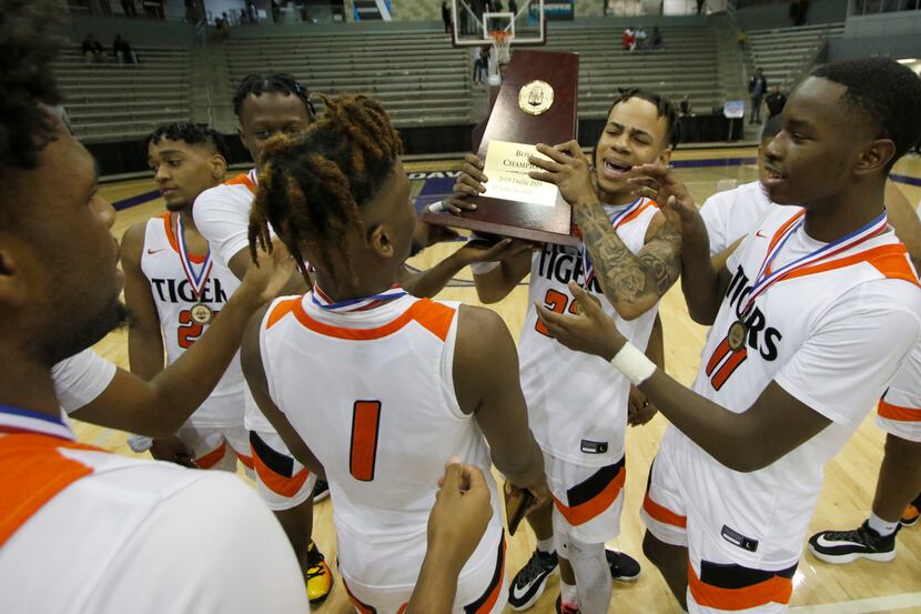 Lancaster forward Darius Davis (23) holds the championship trophy as he celebrates with...