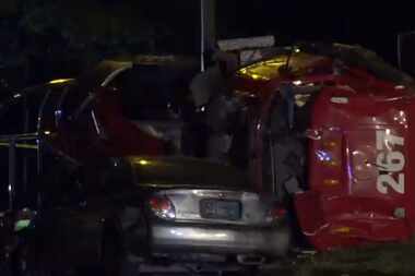 An overturned 18-wheeler lies against a car that crashed into it Tuesday night in...